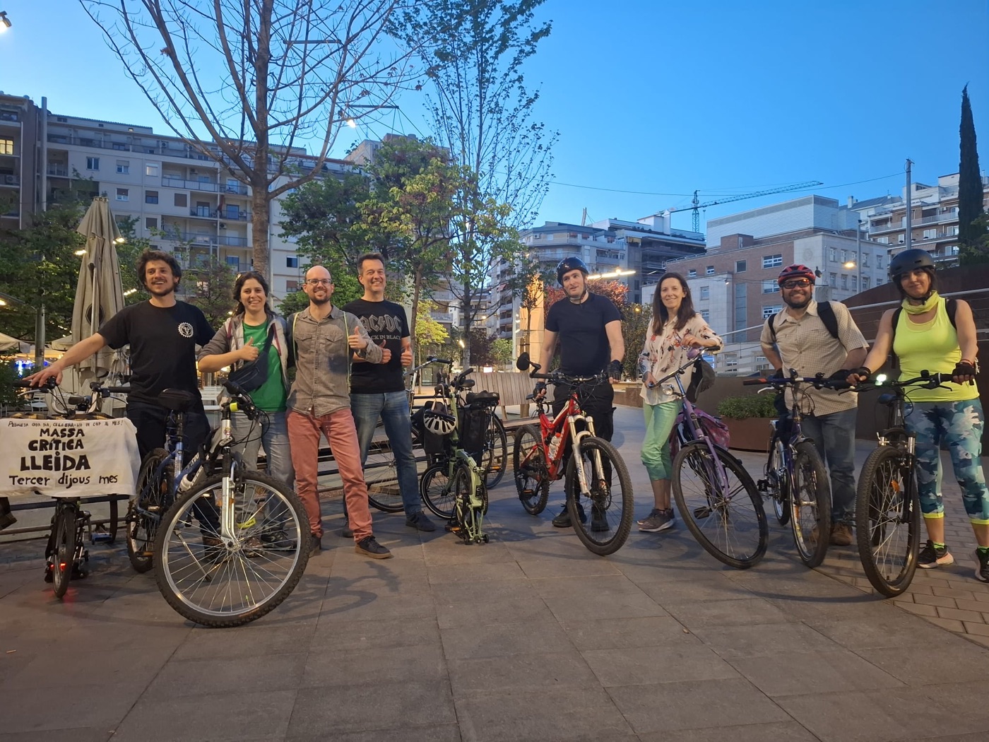 Grup de participants amb les seves bicicletes en una Massa Crítica de Lleida, amb la pancarta 'Massa Crítica Lleida, tercer dijous de mes'.