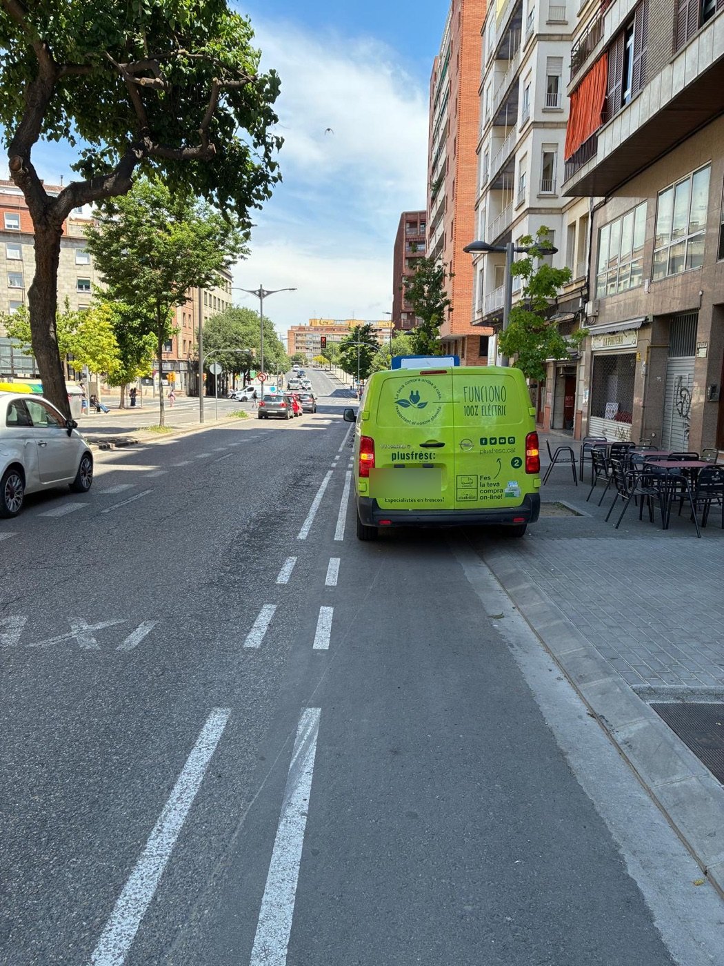 Una furgoneta de repartiment aturada sobre el carril bici d'una avinguda de Lleida.